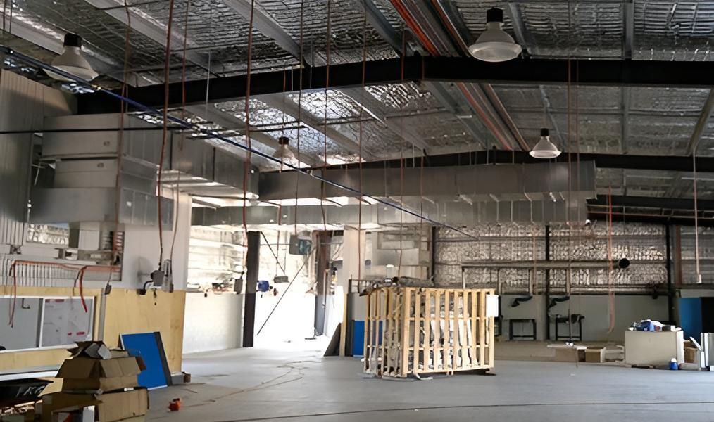 A Large Warehouse With a Lot of Pipes Hanging From the Ceiling — FVS Airconditioning & Electrical Pty Ltd in Boulia, QLD