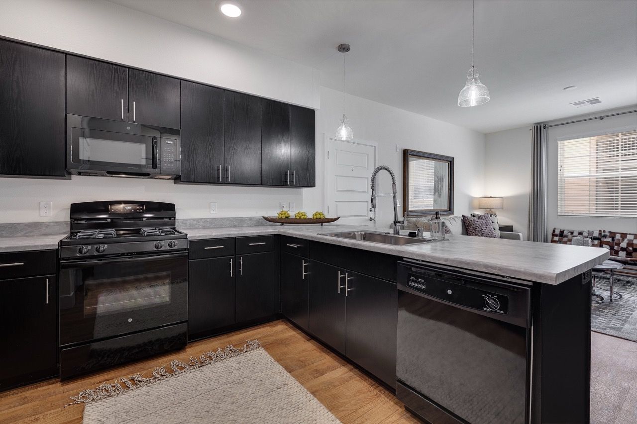 Kitchen with dark wood cabinets, stainless steel appliances, and an island with a sink.