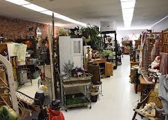 An appraisal and consignment counter with antique items and paperwork in a vintage store.