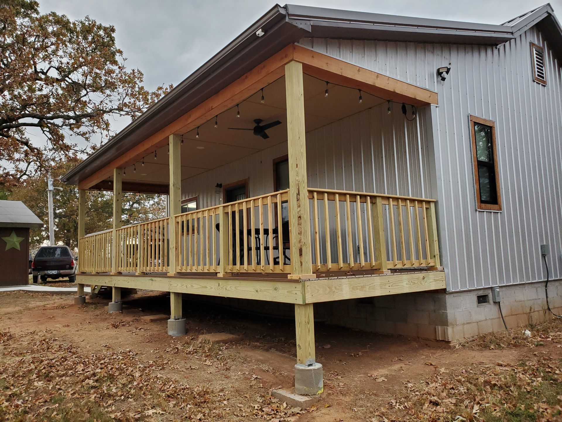 A small house with a porch and a wooden deck