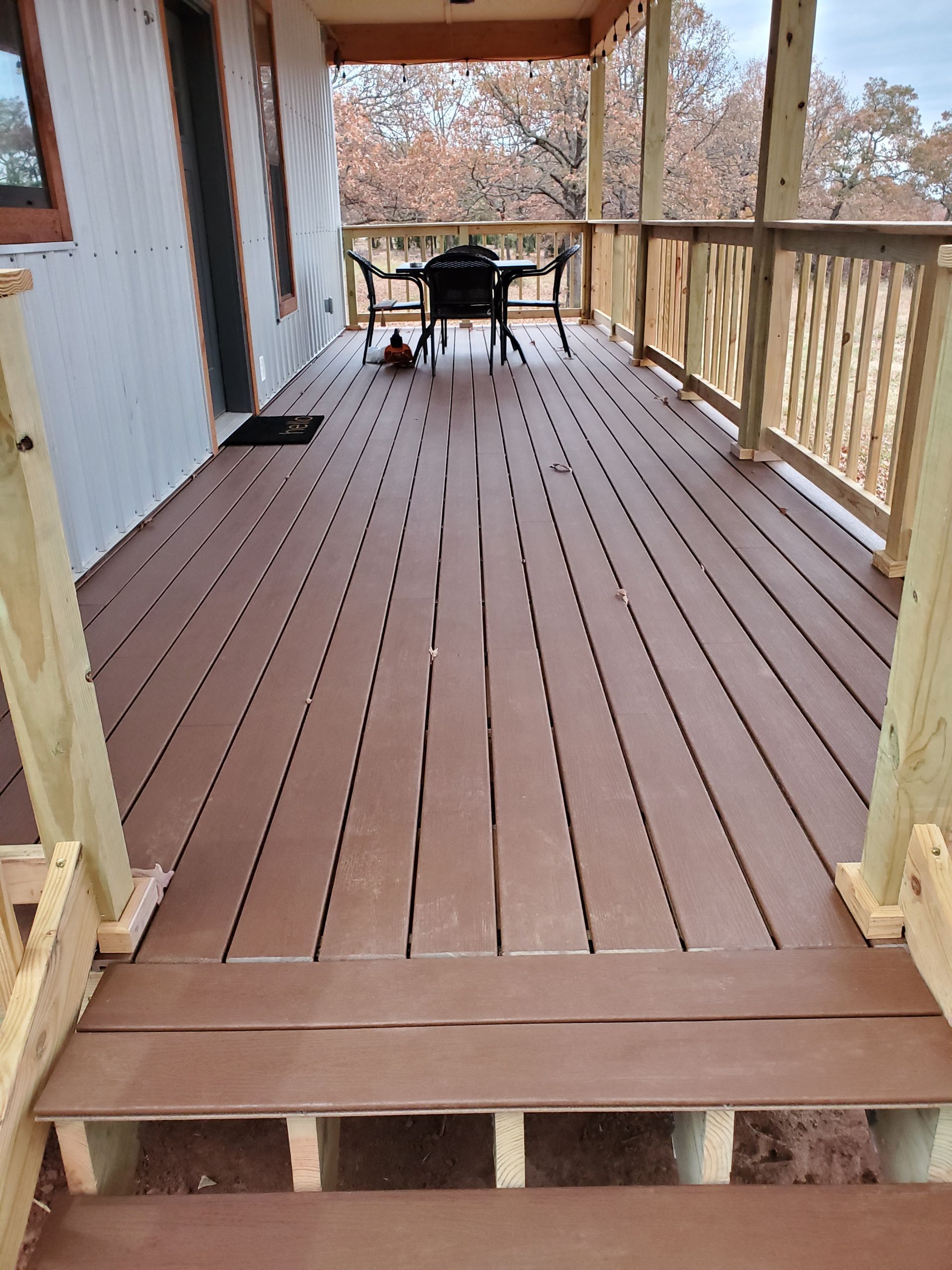 A wooden deck with a table and chairs on it.