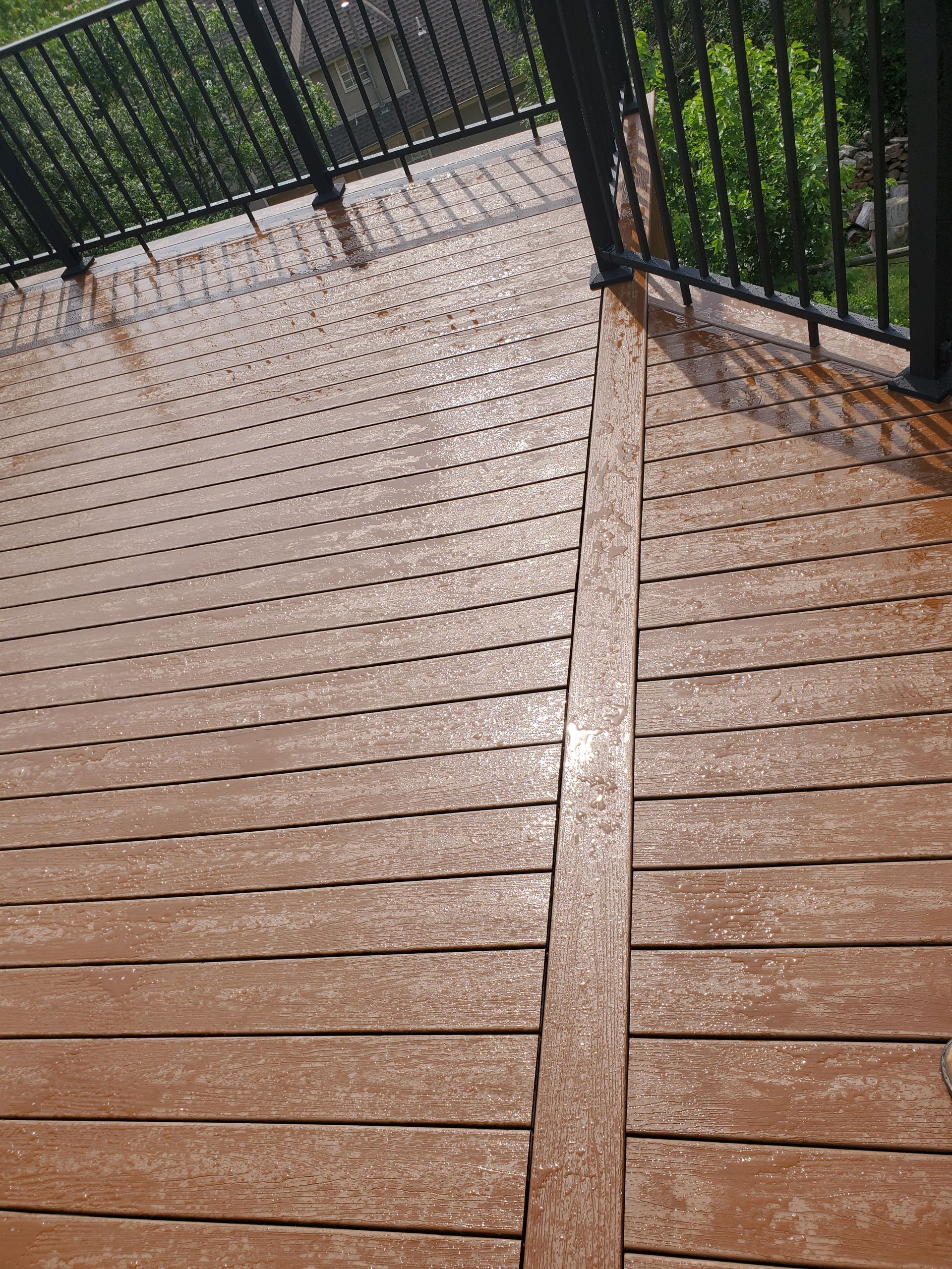 A close up of a wooden deck with a metal railing.