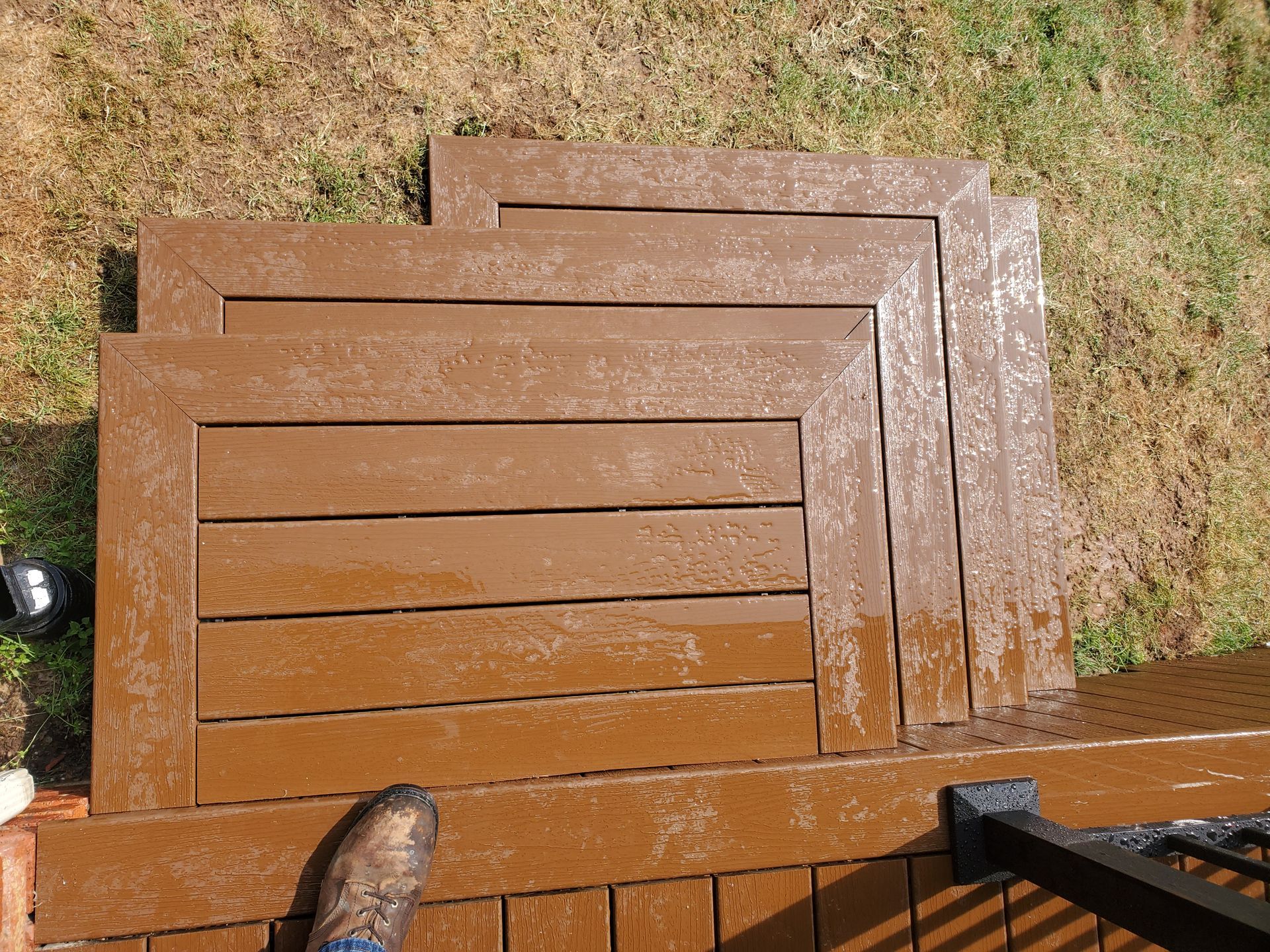 A person standing on a wooden deck with a staircase in the background
