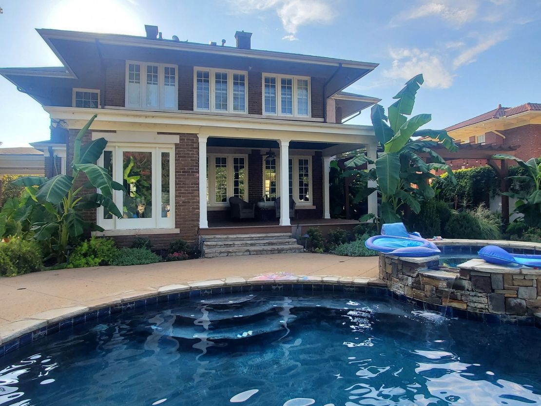 A large house with a swimming pool in front of it