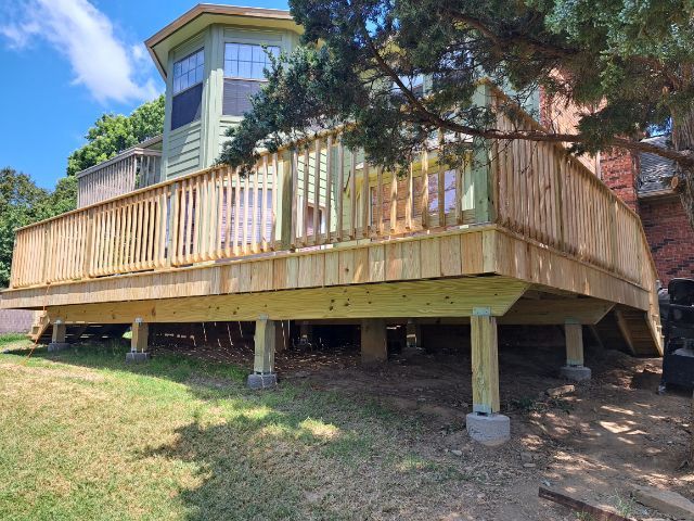 A large wooden deck is sitting on top of a house.