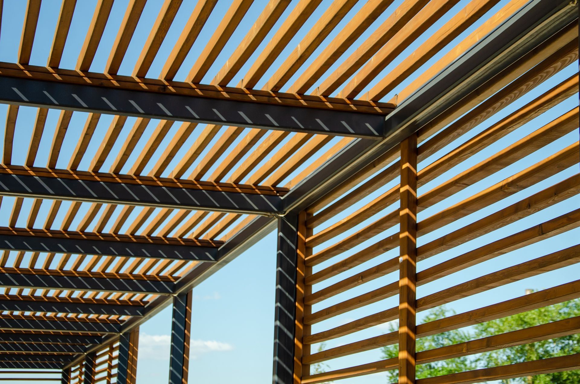 A wooden pergola with a blue sky in the background.