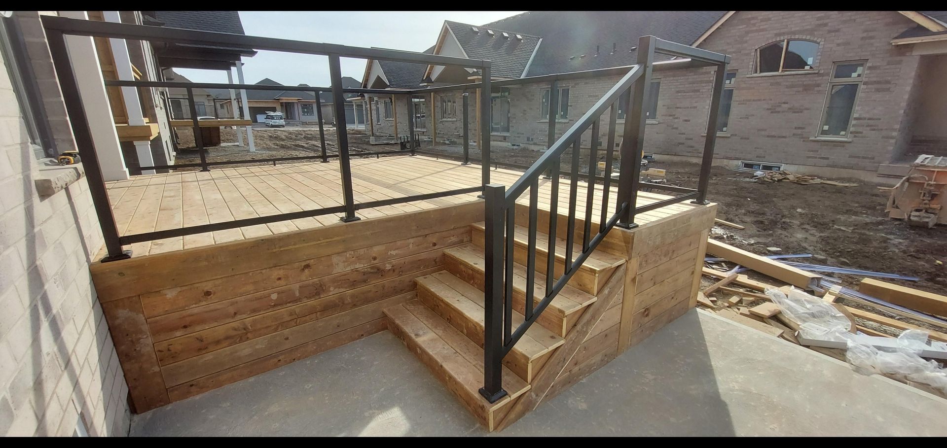 A wooden deck with stairs and a metal railing.