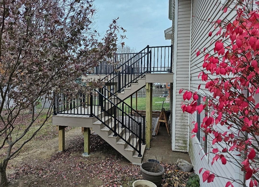 A house with a deck and stairs leading up to it.