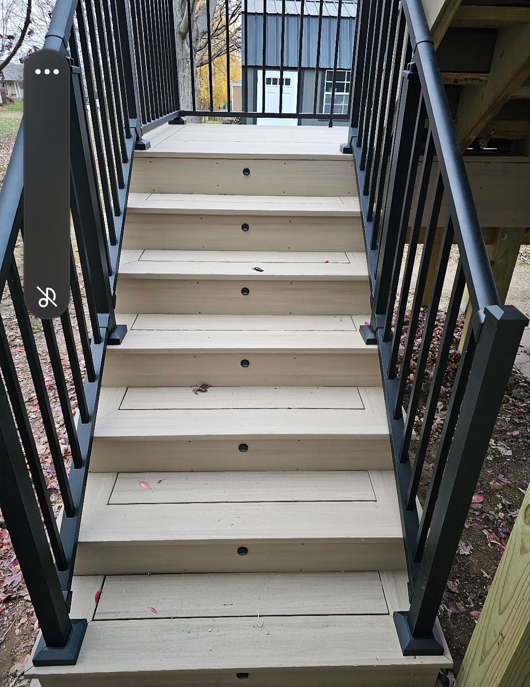 A set of stairs leading up to a deck with a black railing