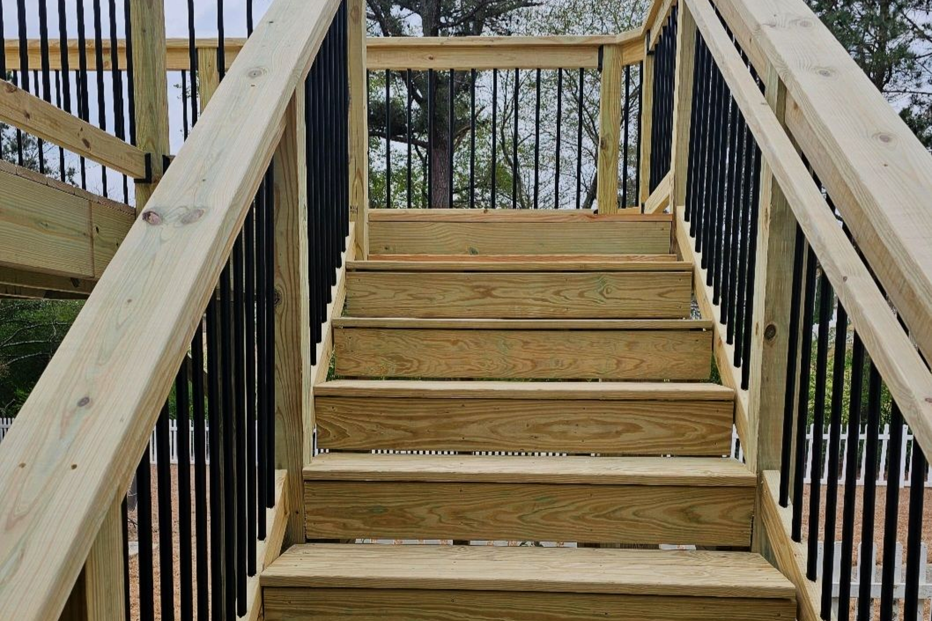A set of wooden stairs with a metal railing