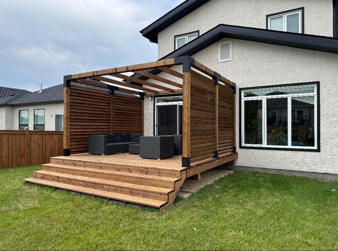 A wooden deck with a pergola in the backyard of a house.
