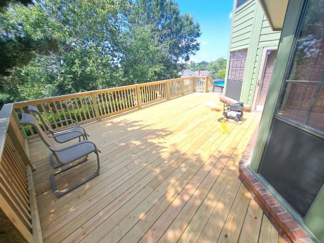 There is a large wooden deck with chairs on it.