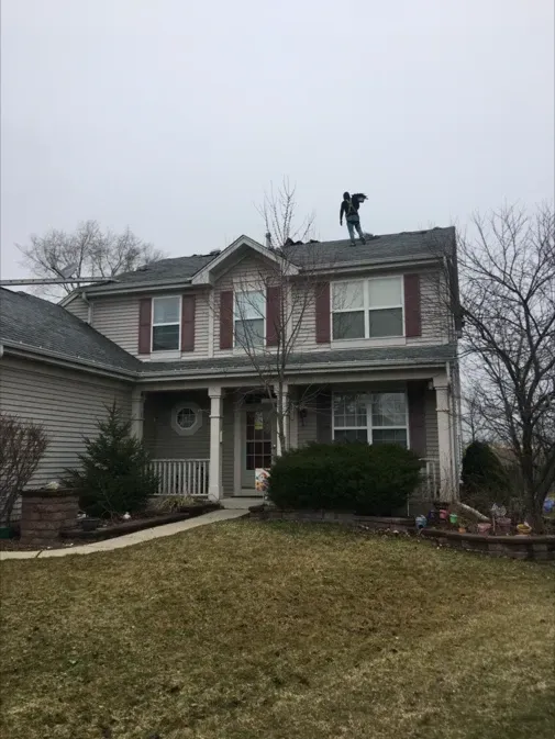 A man is working on the roof of a house.
