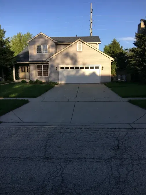 A house with a white garage door and a large driveway