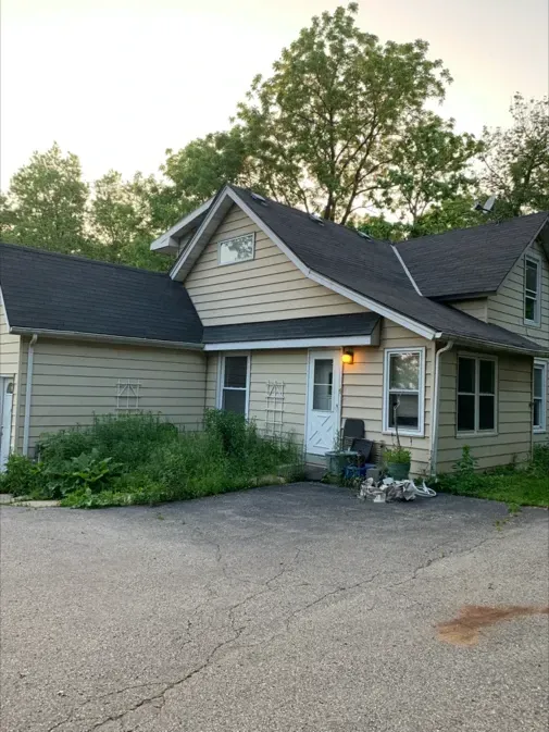 A house with a black roof and a white door