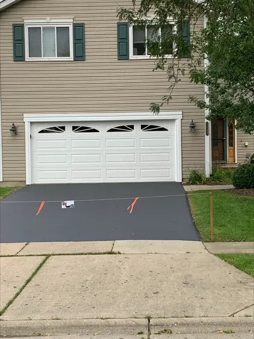 A house with a white garage door and a gray driveway