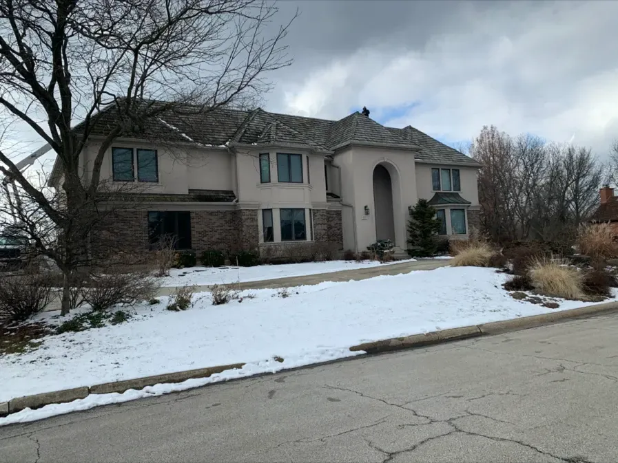 A large house with snow on the ground in front of it