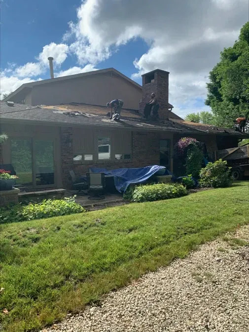 A man is working on the roof of a house.