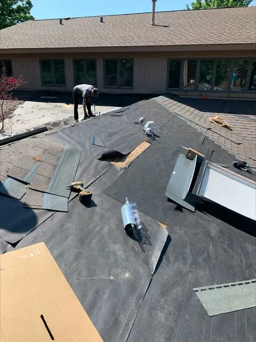 A man is working on the roof of a house.