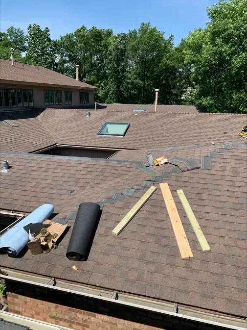 A roof with a skylight is being installed on a house.