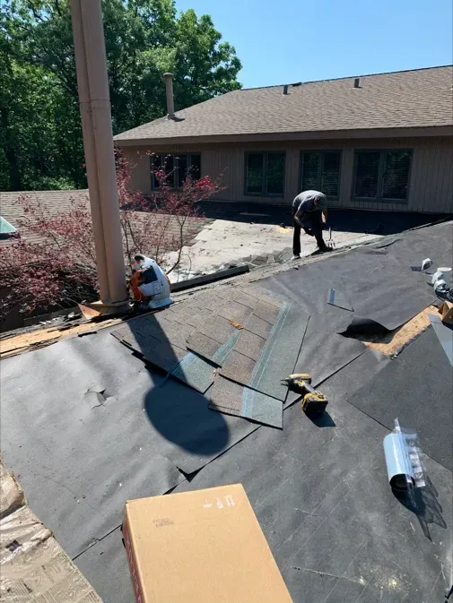 A man is working on the roof of a house.