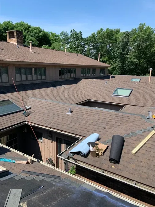 A roof with a lot of rolls of shingles on it