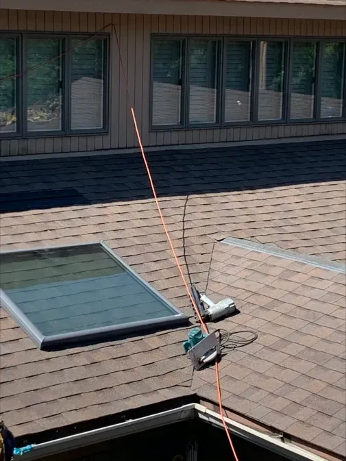 A roof with a skylight and a antenna on it