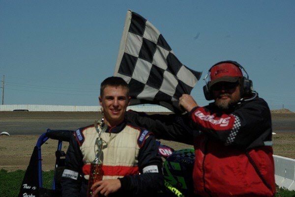 A man holding a checkered flag next to another man