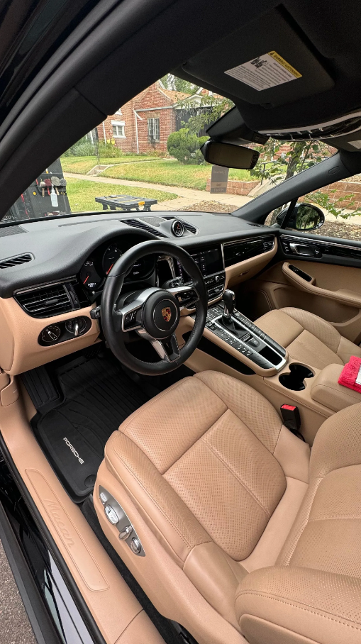 Black GMC Sierra Denali truck parked outside a building on a sunny day.