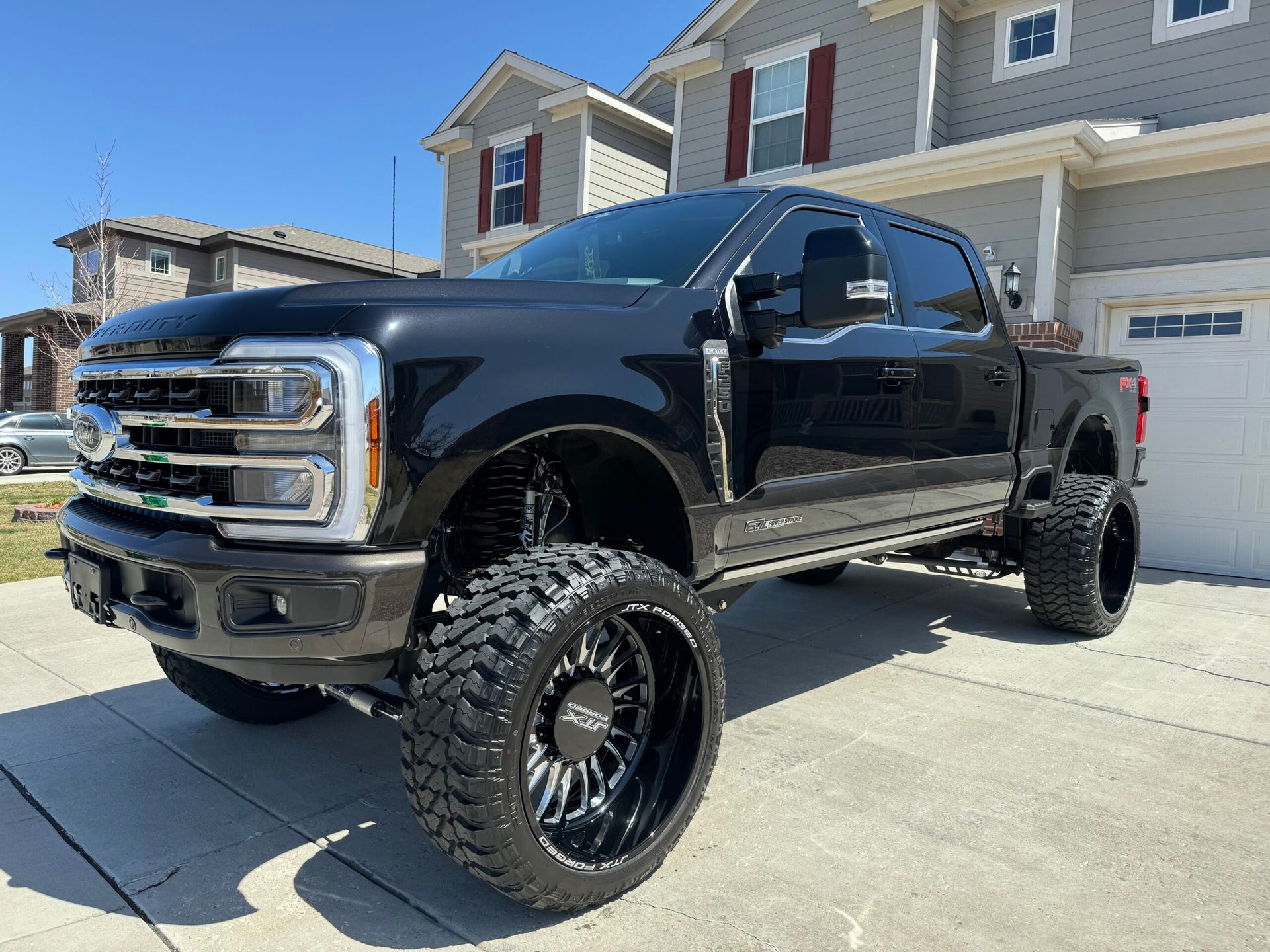 A black pickup truck is parked in front of a house.