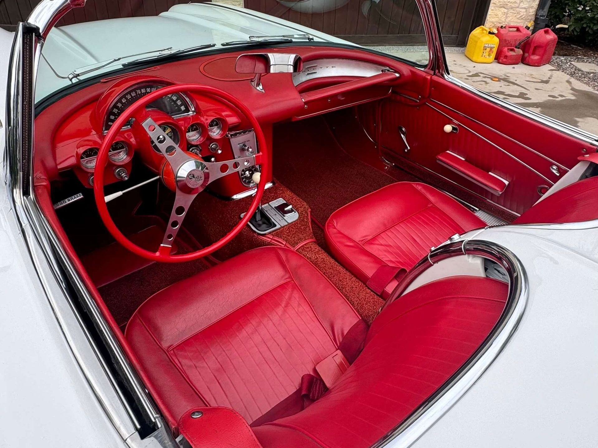 A white car with red seats and a red steering wheel