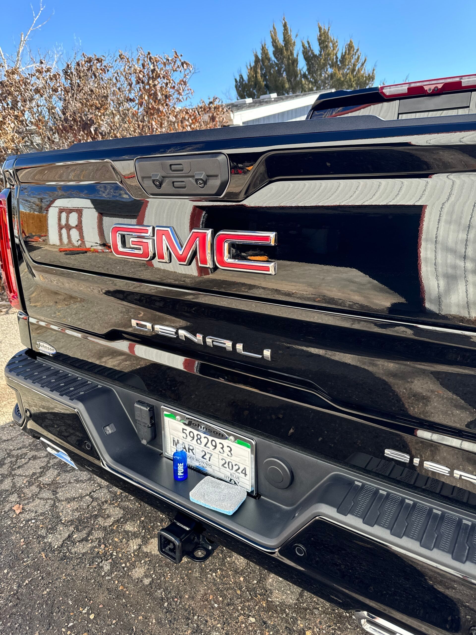 A black gmc truck is parked on the side of the road.