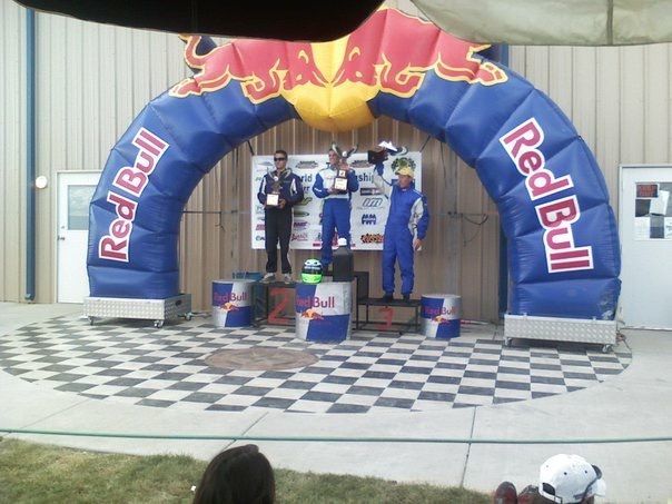 A group of people standing under an inflatable red bull arch