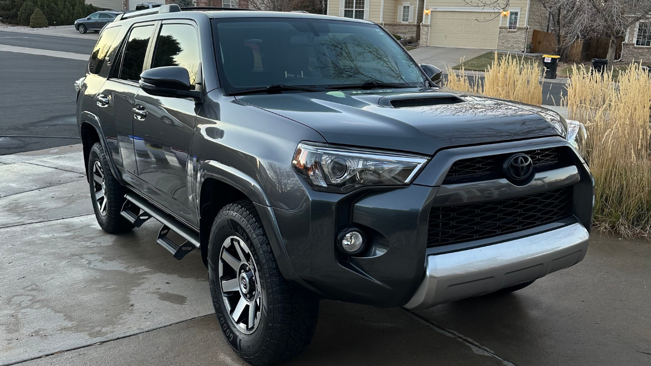 A toyota 4runner is parked in a driveway in front of a house.