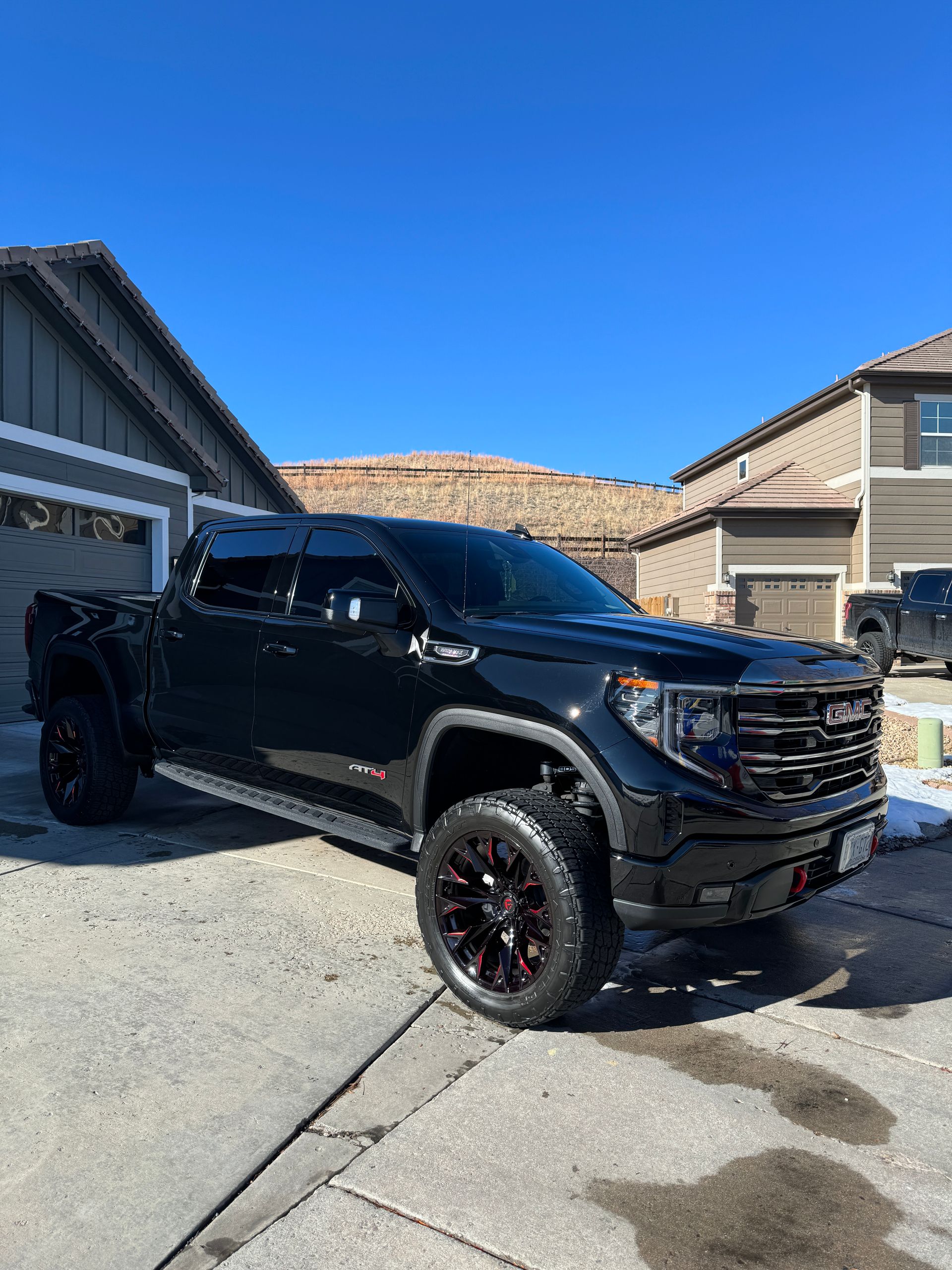 A black truck is parked in front of a house.