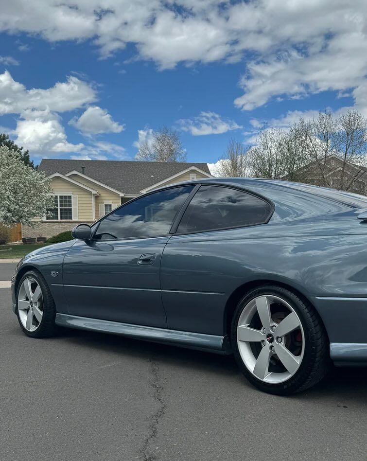 A car is parked on the side of the road in front of a house