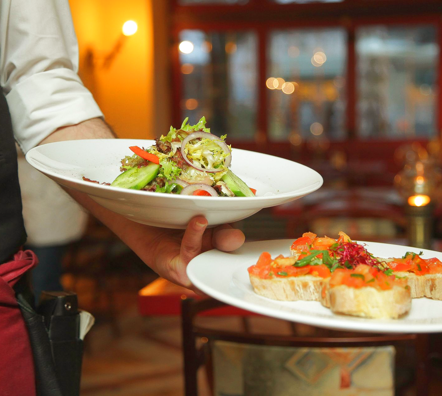 Chef plating mushroom appetizers with dry ice on wooden platters.