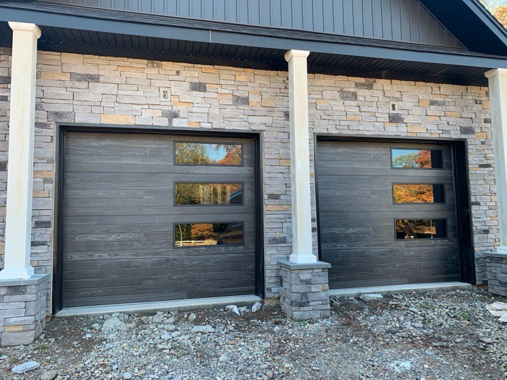 There are two garage doors on the side of a house.