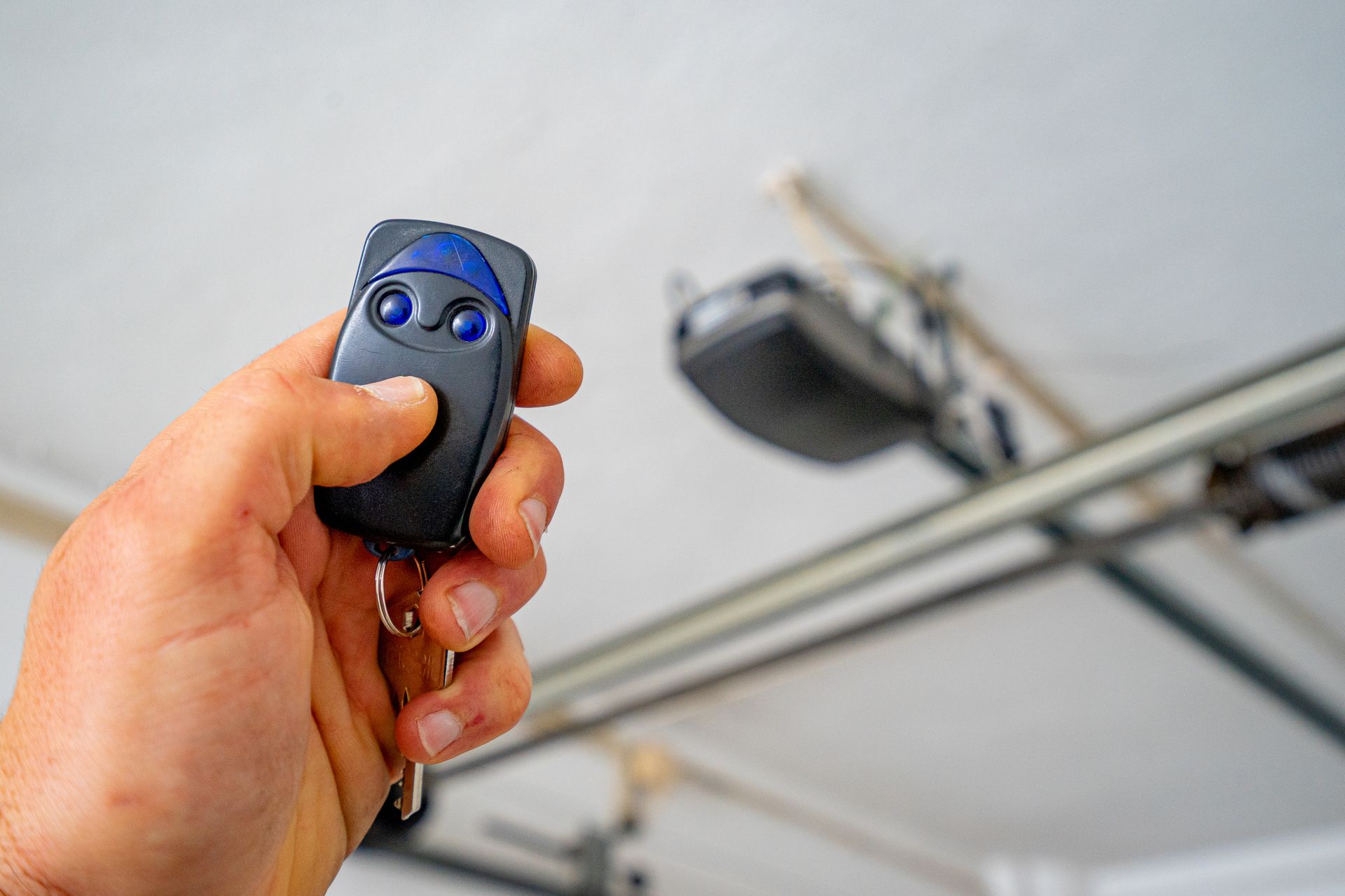 Close-up of modern garage door openers installed on ceiling with safety sensors and wiring.