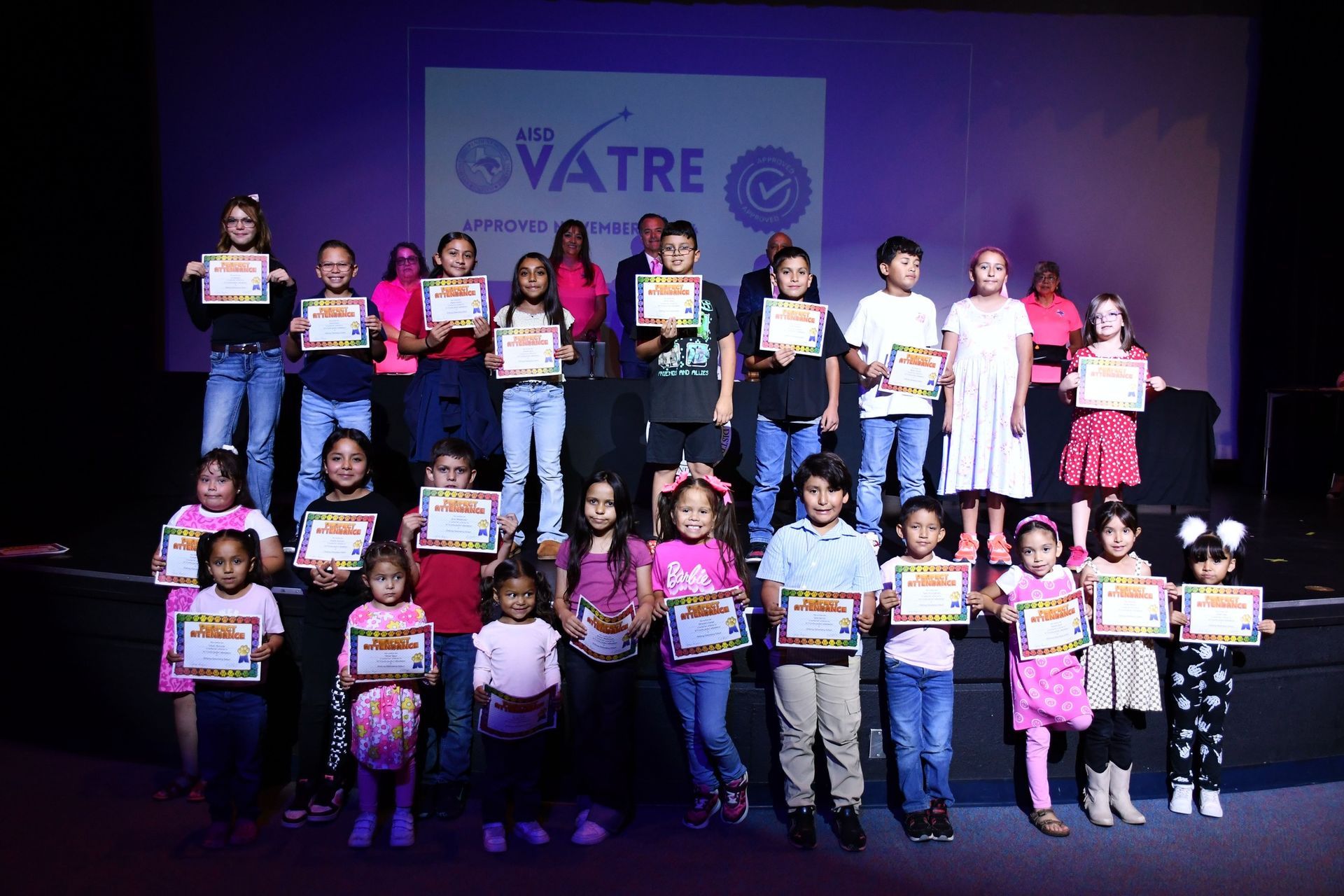 Large group of Anthony Elementary School students stand in front of Anthony ISD Board of Trustees while they hold their perfect attendance certificates.