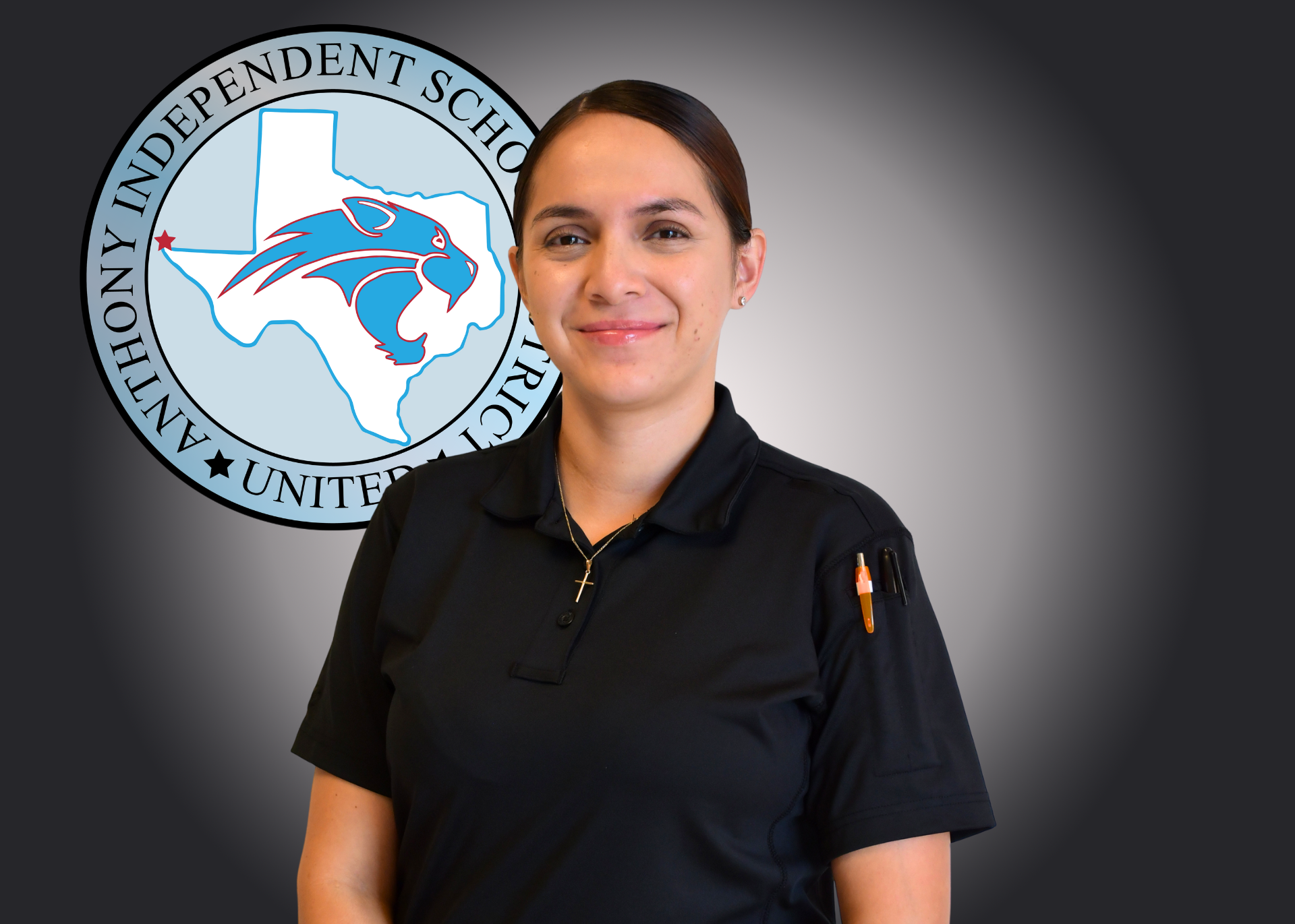Woman wearing black shirt stands in front of Anthony ISD logo.