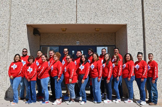 Teachers standing in a group with shirts that say