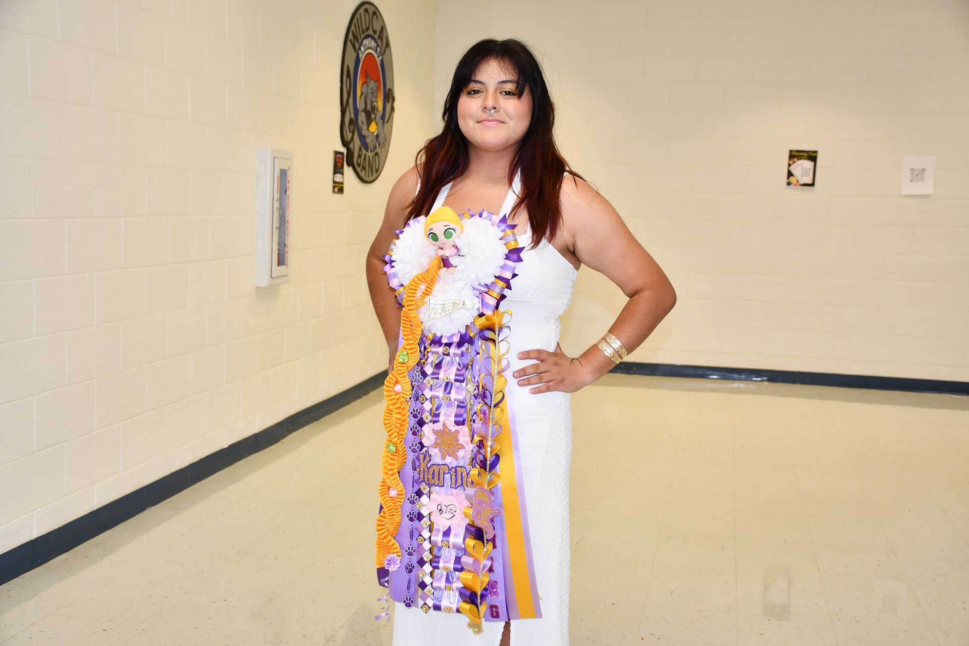 Student wears mum and smiles at camera.