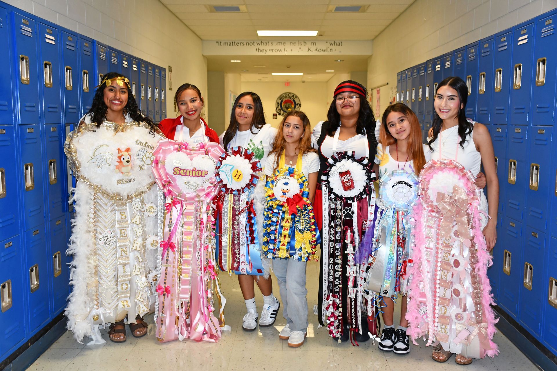 Students stand in a line while wearing mums