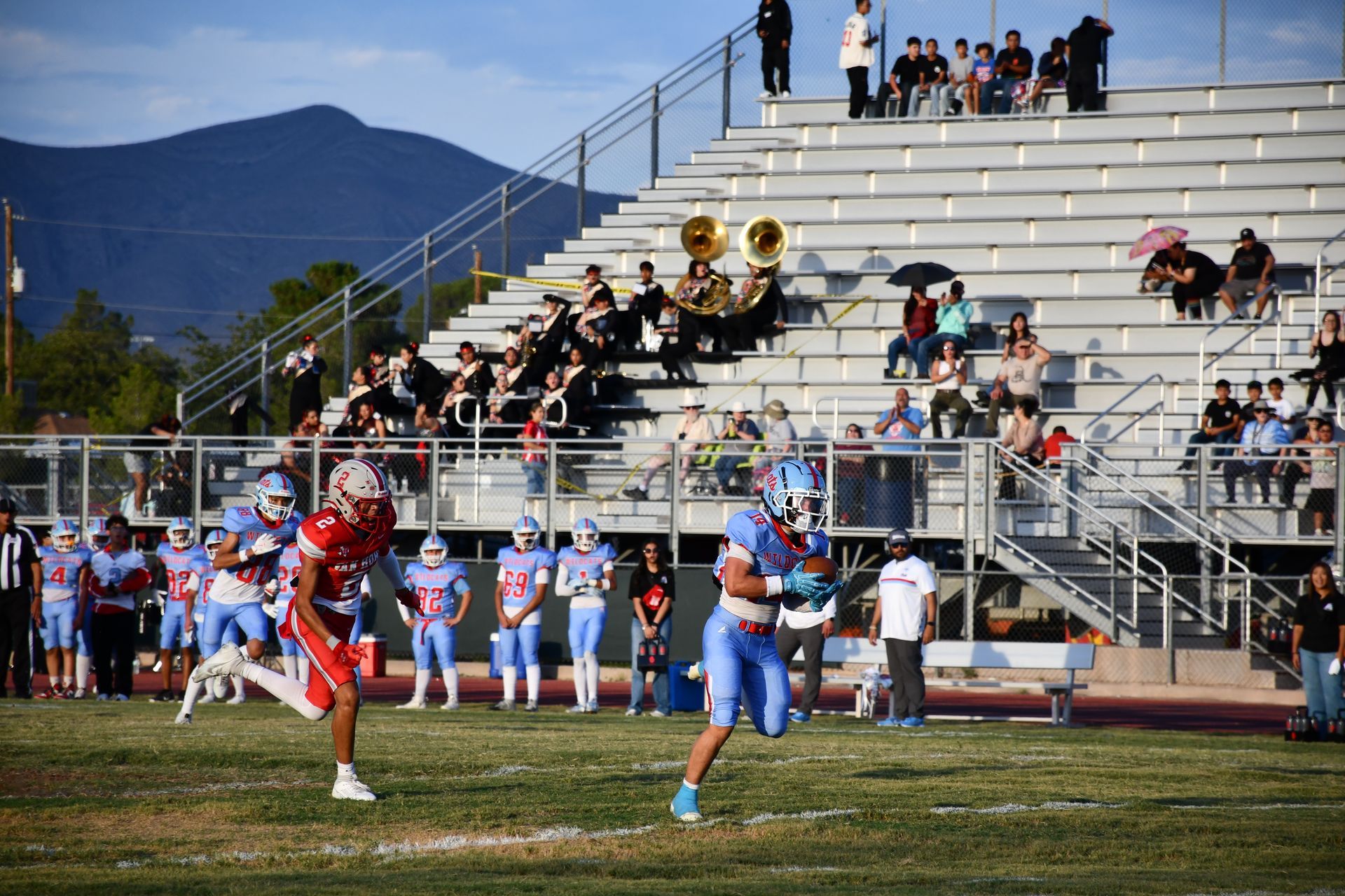 Fotball player runs the ball while opposing team tries to tackle him.