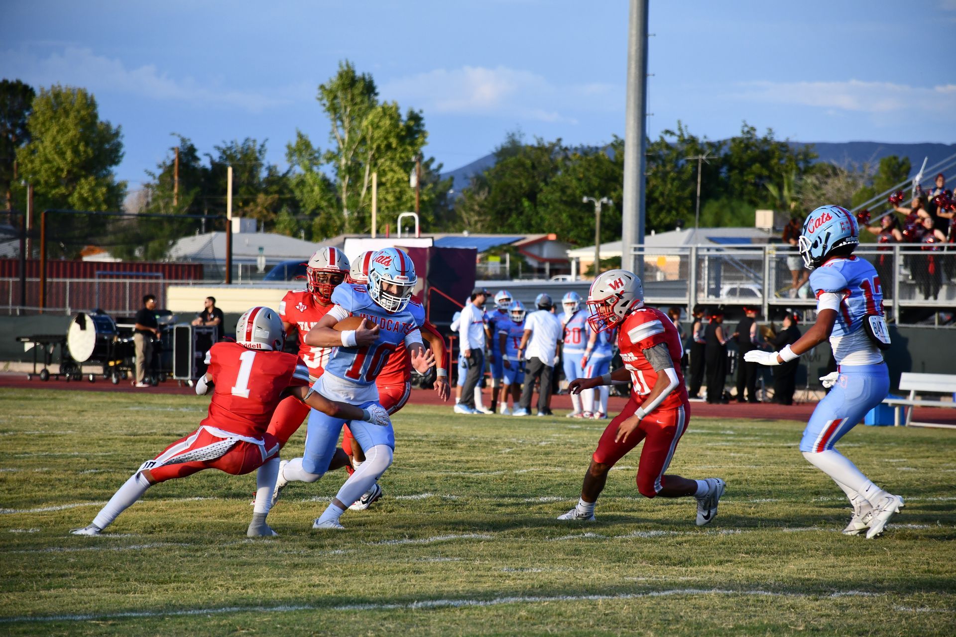 Fotball player runs the ball while opposing team tries to tackle him.