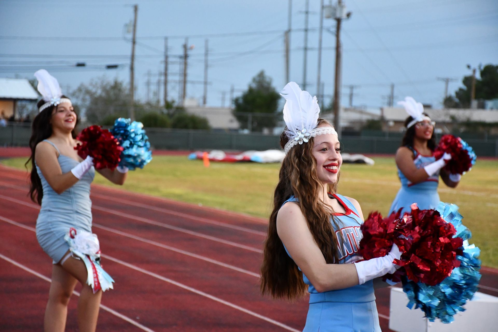 Cheerleaders smile and wave pom-poms