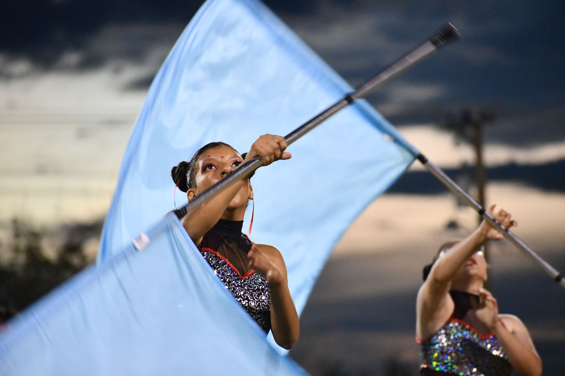 Female color guard student waves blue flag
