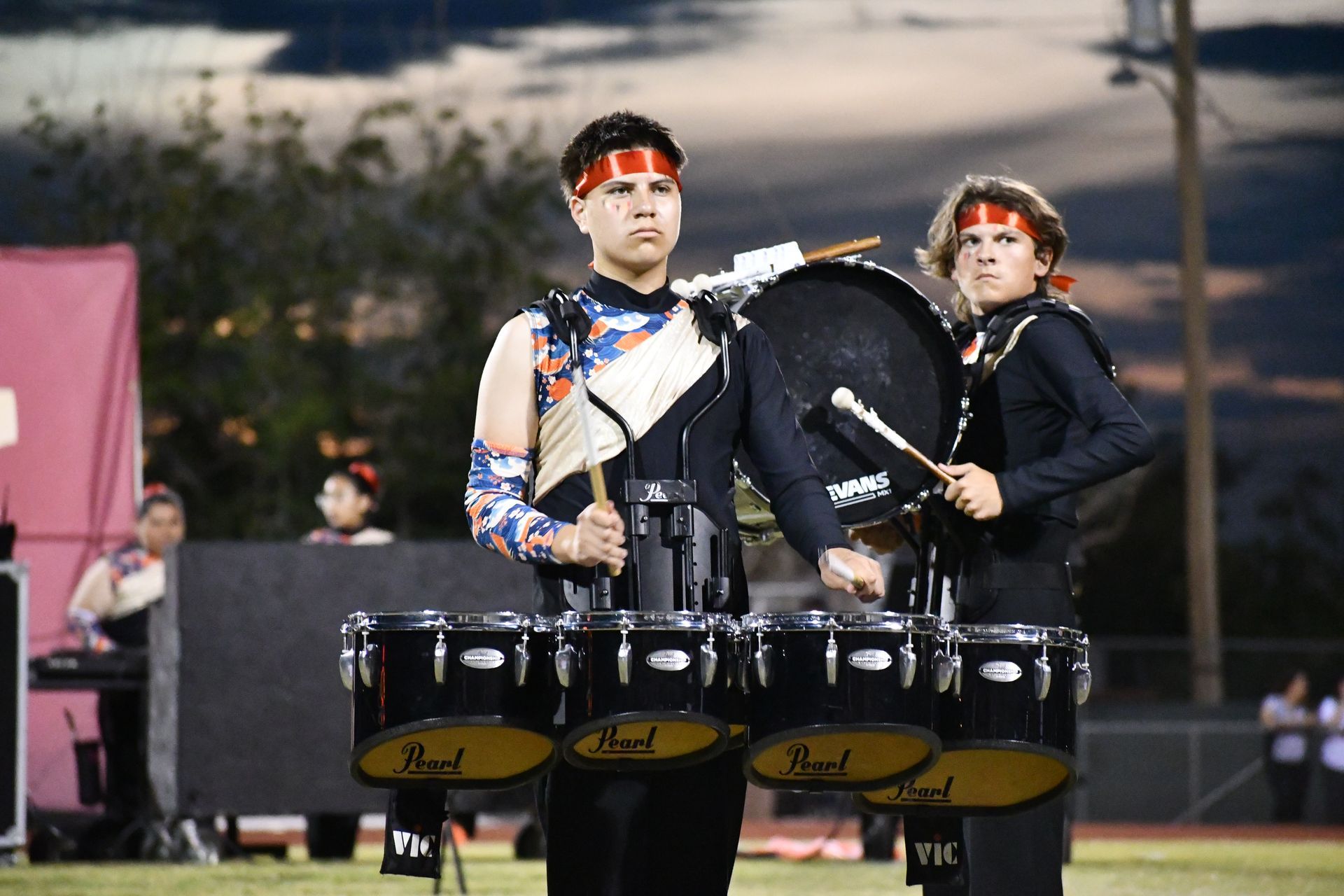 Two Anthony band students play the drums while intensely looking into thr crowd during their halftime performace on the football field.