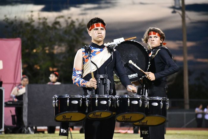 Two Anthony band students play the drums while intensely looking into thr crowd during their halftime performace on the football field.